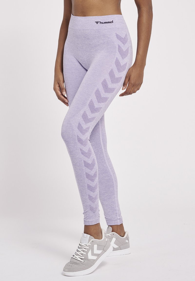 Lichtpaarse legging met een hoge tailleband, voorzien van een chevronpatroon aan de zijkanten. Gemaakt van een zachte, rekbare stof.