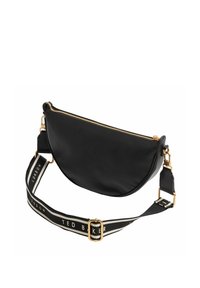 Sac bandoulière en cuir noir à la forme courbée, avec une fermeture éclair dorée et une sangle en tissu rayé portant les inscriptions "TED BAKER" et "LONDON".