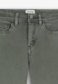 Jeans de mezclilla verde oliva con un corte ajustado, que cuentan con cinco bolsillos, un cierre de botón frontal y un logo bordado en el bolsillo frontal.