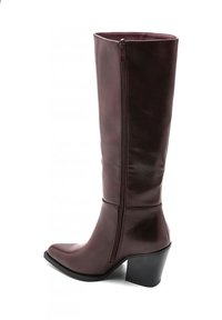 Botte en cuir bordeaux montant jusqu'au genou, avec une fermeture éclair sur le côté, un bout pointu et un talon épais noir. Fini lisse avec des accents de design minimaux.