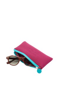 Brązowe okulary przeciwsłoneczne leżące obok różowo-fioletowej i turkusowej saszetki na zamek o gładkiej fakturze, z logo wytłoczonym na przodzie.