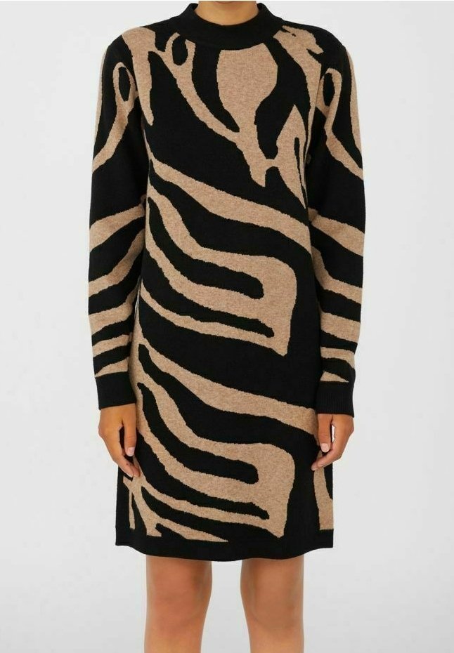 Robe-pull à manches longues, longueur genou, avec motif abstrait zèbre noir et beige sur une personne debout.