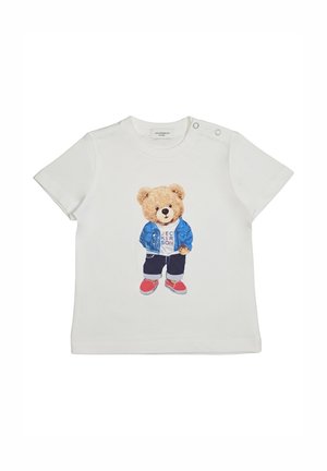 Maglietta bianca per bambino piccolo con un orsetto che indossa una giacca blu, pantaloni scuri, scarpe rosse e una maglietta bianca con testo sulla parte anteriore.