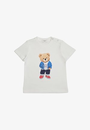 Maglietta bianca per bambino piccolo con un orsetto che indossa una giacca blu, pantaloni scuri, scarpe rosse e una maglietta bianca con testo sulla parte anteriore.