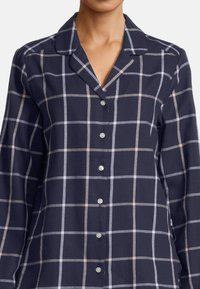 Marinrutigt skjorta med vit och ljusrosa rutmönster, med krage och pärlliknande knappar fram.