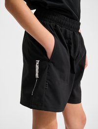 Svarta träningsshorts med elastisk midja, sidofickor och Hummel-logotyp i vitt längs vänster ben. Slät textur.