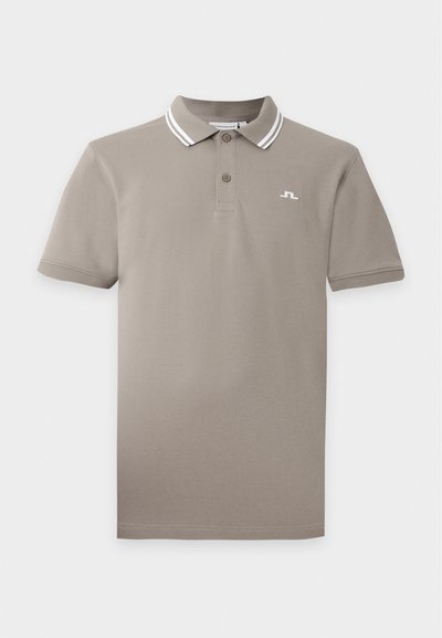 Polo beige à manches courtes avec patte à deux boutons et col rayé blanc, avec un petit logo blanc sur le côté gauche de la poitrine.