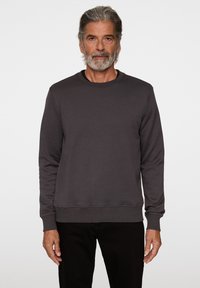 Grå sweatshirt i mjukt material, med rund hals, långa ärmar och ribbade muddar och nederkant. Enkelt design med minimal logga.