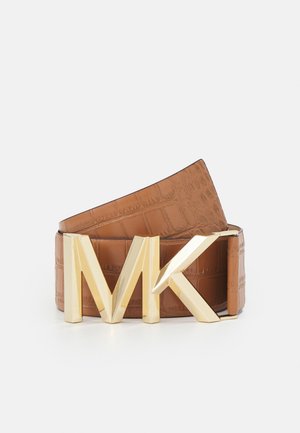 Ceinture en cuir marron à texture crocodile avec une grande boucle métallique dorée aux initiales MK sur fond blanc.