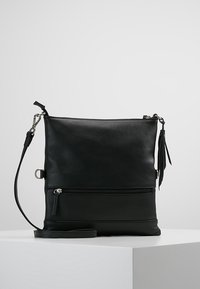 Czarna skórzana torebka na ramię o fakturowanym wykończeniu, z przednią kieszenią na zamek, regulowanym paskiem i ozdobą w postaci frędzla.