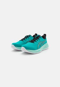 Baskets de sport turquoise avec accents noirs, tige en mesh léger, semelle rembourrée et détail de logo distinctif sur le côté.