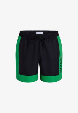Pantaloni da bagno neri con pannelli laterali verde brillante. Presentano una cintura elastica con cordoncino e un logo stampato di lato.