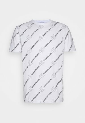 Witte katoenen t-shirt met een overal herhaald zwart "Calvin Klein Jeans" logo in verschillende oriëntaties. Ronde hals, korte mouwen.