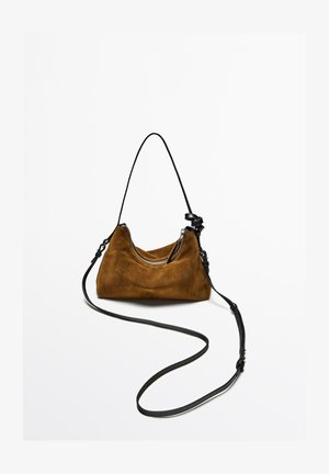 Brown suede handbag with a curved shape, featuring a black adjustable strap and a silver zipper accent on the top opening.