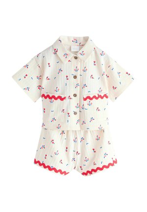 White short-sleeve button-up shirt and matching shorts with red floral print and red wavy trim on pockets and shorts hem.
