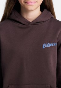 Brązowa bluza z kapturem wykonana z mieszanki bawełny. Oferuje niebieskie logo "ELEMENT" na lewej piersi. Miękka tekstura, luźny krój.