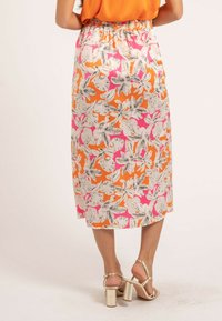 Jupe midi florale avec un motif vif orange et rose, rehaussé de contours noirs. Taille élastique, tissu doux et coupe droite.