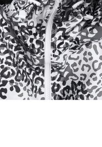 Lätt vindjacka i vitt och grått leopardmönster, med främre dragkedja, justerbara snören och slät, glänsande yta.