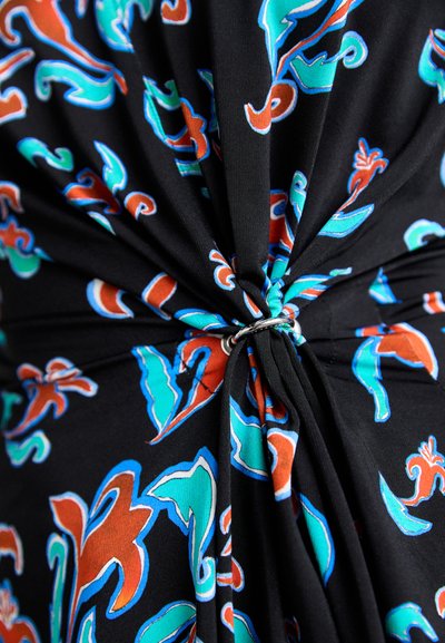 Black fabric with a floral pattern in red and turquoise, featuring a twisted design secured by a silver ring detail.