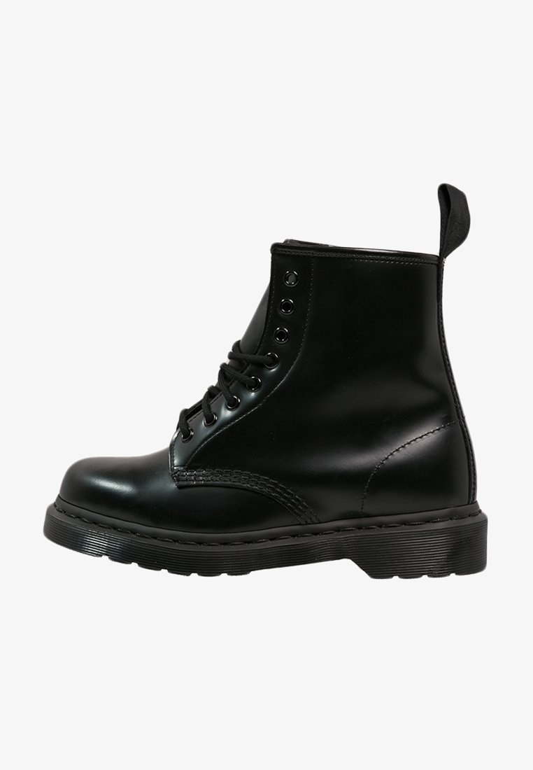 Bottine en cuir noir avec huit œillets, lacets noirs, languette à l'arrière, semelle épaisse avec grip texturé, vue de profil latéral.