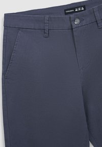 Granatowe spodnie z mieszanki bawełny z zapięciem na guzik, szlufkami na pasek oraz dwiema przednimi kieszeniami, charakteryzujące się gładką teksturą i dopasowanym krojem.