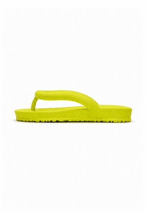 Sandalia tipo flip-flop de espuma de color amarillo brillante con suela gruesa y tira ancha, mostrada de lado sobre un fondo blanco.