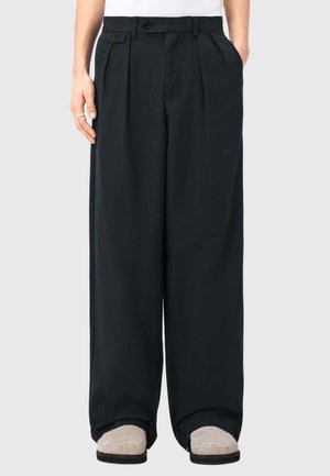 Czarne spodnie o szerokich nogawkach, wykonane z gładkiej tkaniny, z przodu z zakładkami, dwoma bocznymi kieszeniami i zapięciem na guzik w talii.