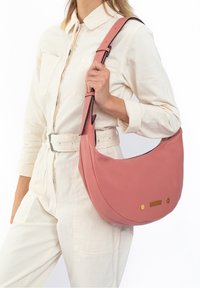 Pink leather shoulder bag with a curved shape, featuring gold hardware accents and a contrast stitching detail. Smooth texture throughout.