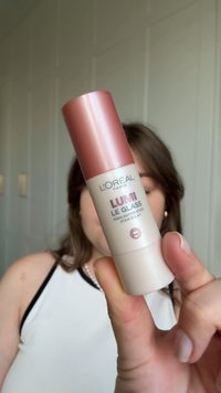 L'Oréal Paris Lumi Le Glass highlighter stick in een twee-kleurig ontwerp: rosegouden metalen dop en witte cilindrische basis met geprinte tekst.