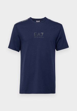 Camiseta de algodón azul marino con mangas cortas, escote redondo y logo de EA7 en un diseño tonal. Acabados metálicos en los hombros. Textura suave.