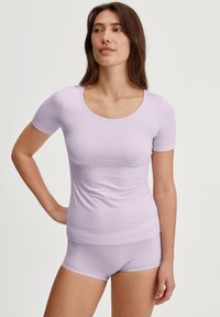 Licht paarse top met korte mouwen en een ronde hals, gecombineerd met bijpassende shorts. De stof lijkt zacht en glad met een aansluitend ontwerp.