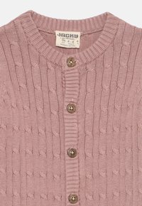 Roza pletena jopica z teksturiranim kablom, rebrastim ovratnikom in petimi lesenimi gumbi spredaj. Oznaka "Jacky."