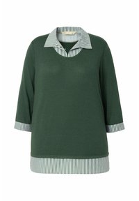 Maglietta verde scuro con maniche a tre quarti, caratterizzata da un collo e dei polsini a righe grigie e bianche, e un orlo arrotondato. Tessuto morbido.