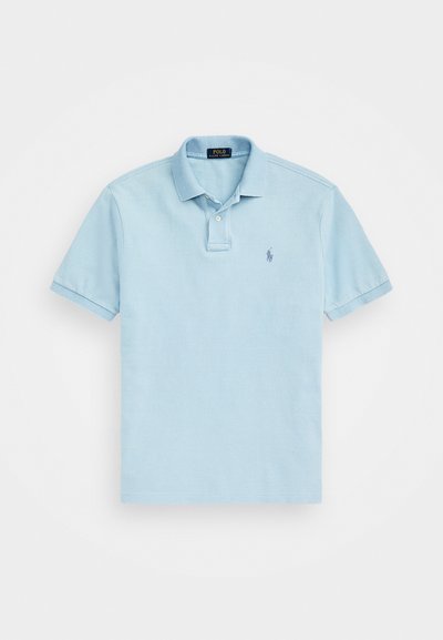 Gaiši zils polo krekls, izgatavots no kokvilnas, ar klasisku apkakli, īsām piedurknēm un izšūtu logotipa detaļu kreisajā krūtī.