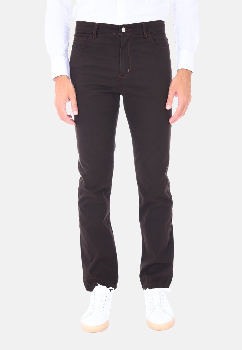 Pantaloni di cotone neri con vestibilità dritta, caratterizzati da dettagli di cucitura arancione, cinque tasche e chiusura con bottone. Indossati con sneakers bianche.