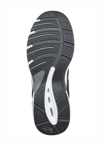 Semelle de chaussure de sport noir et blanc avec caoutchouc texturé, rainures pour la traction et découpes pour la flexibilité, arborant un design lisse et courbé.