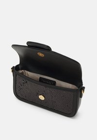 Zwarte leren schoudertas met een textuur oppervlak, gouden hardware en een open klep. Het interieur heeft een stoffen voering en een merklabel.