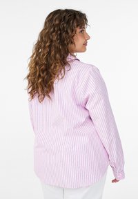 Lichtroze shirt met lange mouwen, voorzien van verticale witte strepen en kleine blauwe stippen. De stof oogt glad, met een ontspannen pasvorm en een afgeronde zoom.