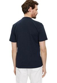 Polo shirt a maniche corte blu navy in cotone, con colletto classico e orlo dritto, visto da dietro.