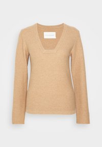 Beige stickad tröja med V-ringning och långa ärmar. Texturerat tyg med en medelstor ruta vid halsringningen. Enkelt design, inga ytterligare dekorationer.