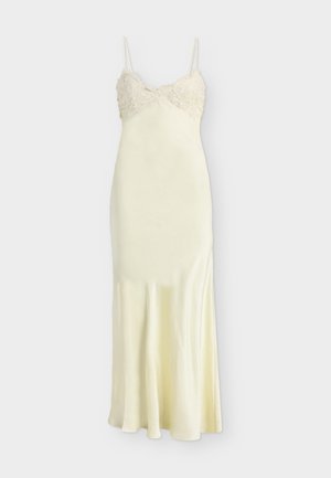 Robe nuisette en soie crème avec un corsage orné de dentelle, fines bretelles et un ourlet évasé.