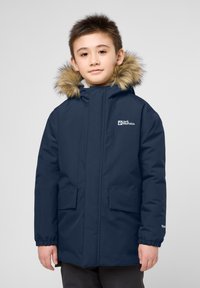 Tmavě modrá parka s kapucí lemovanou kožešinou, dvěma předními kapsami, elastickými manžetami a logem na levé hrudi, navržena pro teplo a pohodlí.