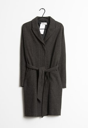 Long manteau en laine gris foncé avec col à revers et ceinture à nouer à la taille, suspendu sur un cintre noir sur fond blanc.