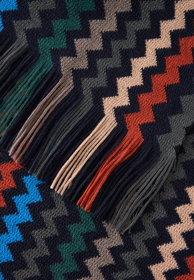 Tissu tricoté à motif zigzag avec franges en bleu, vert, beige, gris, noir et orange.