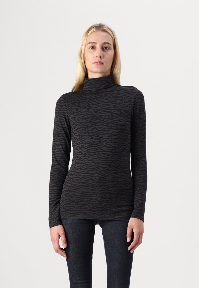 Zwart coltrui shirt met een gestructureerd zebra-patroon, getailleerd ontwerp en lange mouwen, gecombineerd met donkere spijkerbroeken.