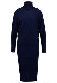 Mekko, jossa on tummansininen poolokaulus ja pitkät hihat. Täydennetty ribbikuvioinnilla, istuva siluetti ja polvikorku. Yksinkertainen malli ilman lisäkuviointeja.