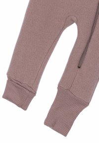 Jumpsuit para bebé de forro polar en rosa empolvado. Presenta puños acanalados y cierre de cremallera. Textura suave con una forma redondeada.
