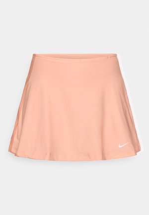 Persiku krāsas sporta svārki, kas izgatavoti no gludas, elastīgas auduma. Iespējas ar izplūdušu dizainu un baltu Nike logotipu apakšējā labajā stūrī.
