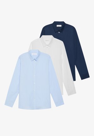Tre camicie a maniche lunghe: azzurra chiara, bianca e blu navy. Tutte hanno un colletto classico e una chiusura con bottoni, realizzate in tessuto liscio.