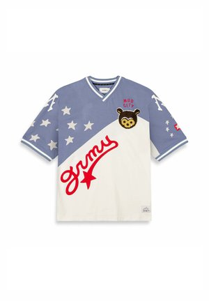 Camiseta de algodón de manga corta con un diseño de bloques de color azul y blanco, patrones de estrellas, un texto rojo "grmy" y un parche de oso etiquetado como "MUD CITY."